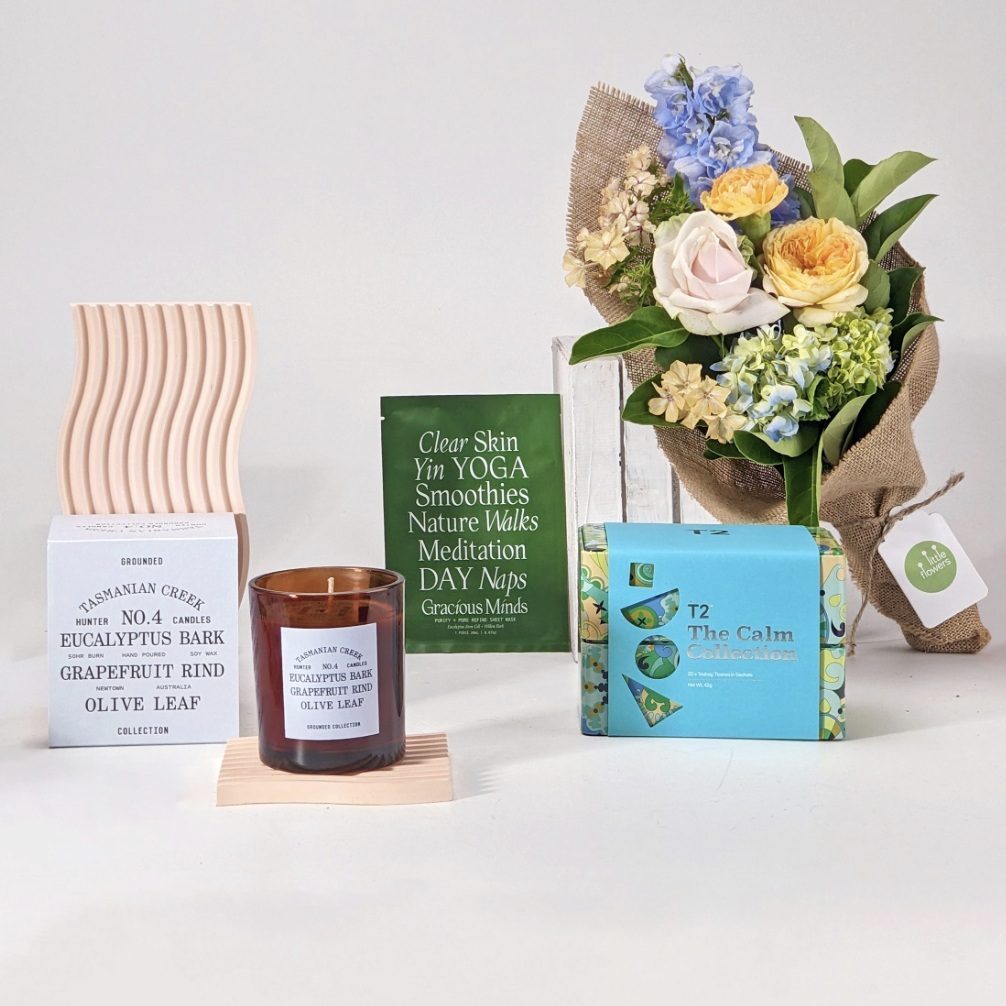 Gift pack with fresh flower bouquet, candle, herbal tea, and sheet face mask