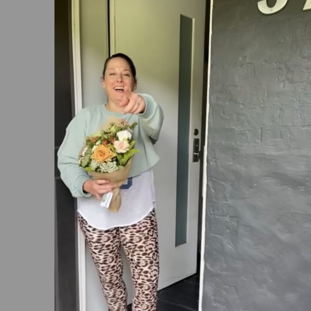 Happy and surprised recipient of flower subscription, holding flower bouquet
