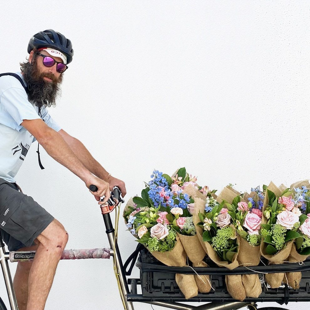 Bike courier with basket full of little flower bouquets