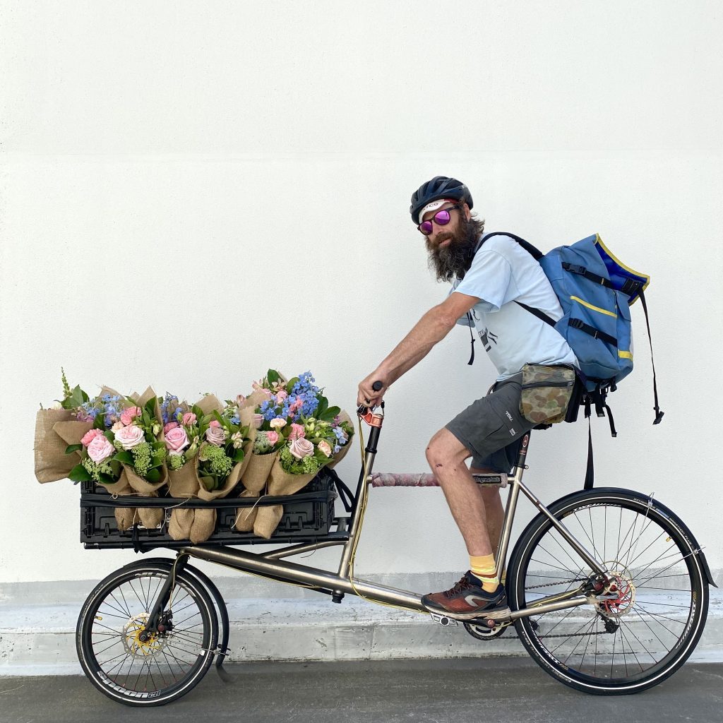 Bike courier delivering bunches of fresh flowers in Sydney