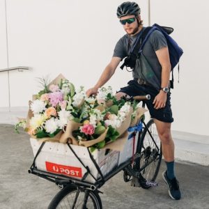 Bike courier delivering fresh flowers in Sydney with a basket full of market bunches
