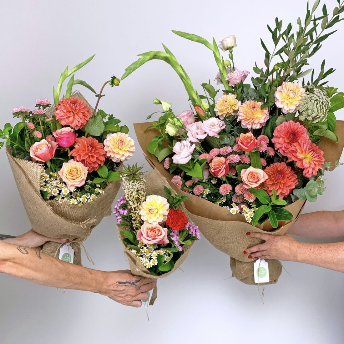 Three different sizes of the daily flower bouquet held by florists
