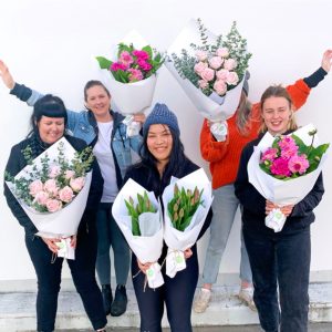 Team holding a variety of single-variety seasonal bunches.