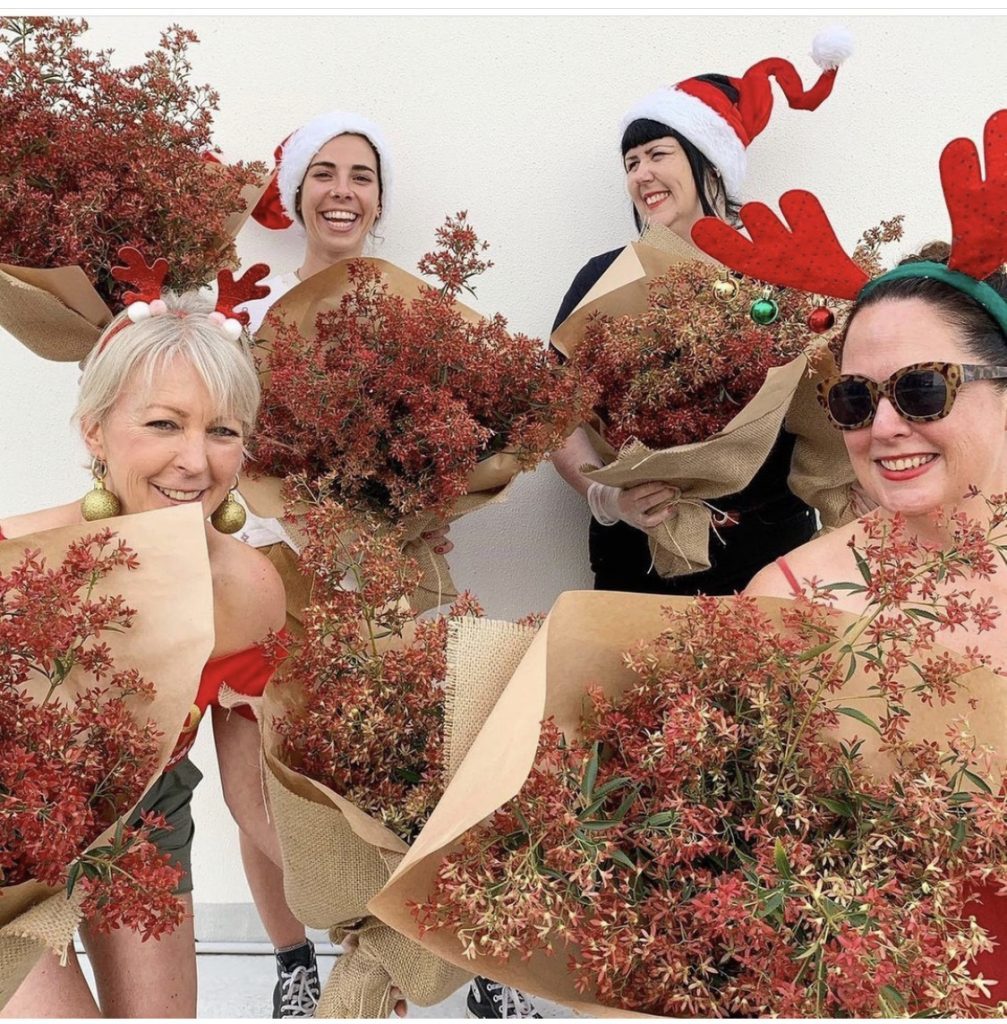 The Little Flowers team holding bunches of Christmas Bush