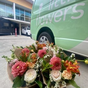 Multiple bunches of flowers outside Alexandria warehouse next to Little Flowers delivery van