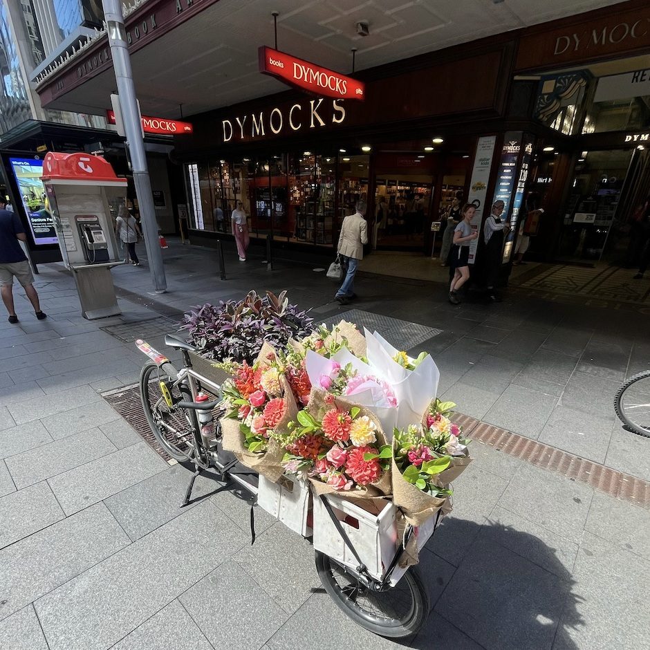 Little Flowers bike courier with bunches outside Dymocks Sydney CBD