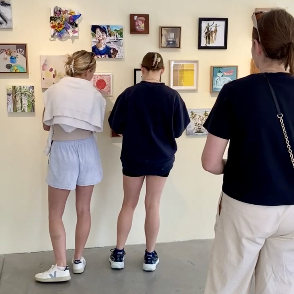 People browsing artworks on the gallery wall