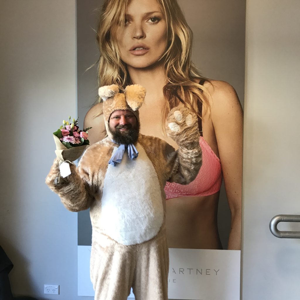 Courier in Easter bunny costume delivering flowers in Alexandria office