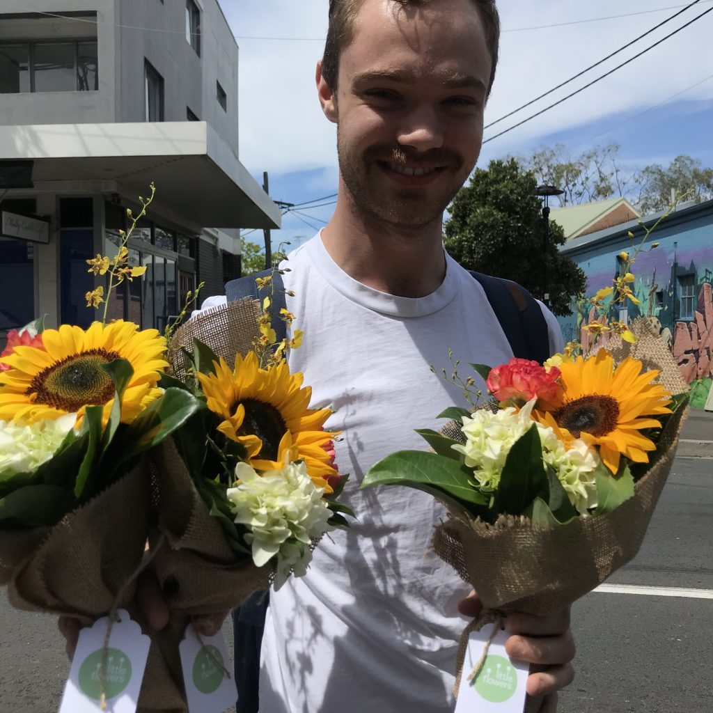 Newtown flower delivery - courier holding sunflower bunches on street