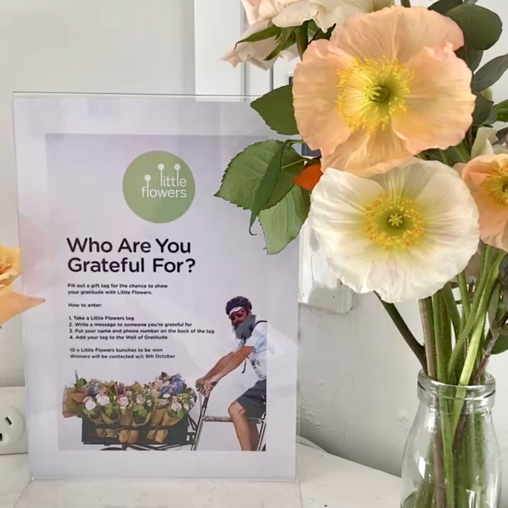 Sign reading “Who Are You Grateful For?” beside flowers