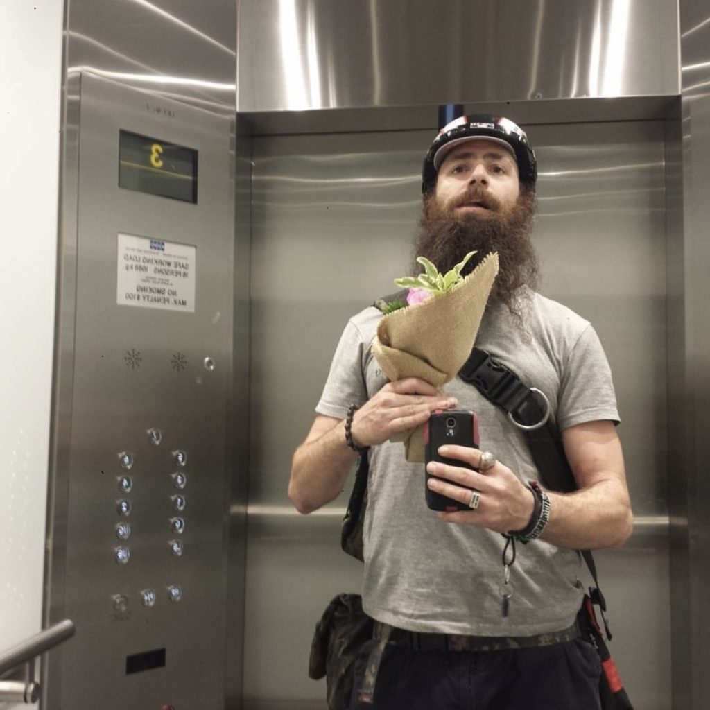 Courier Joe holding a bunch inside an office lift