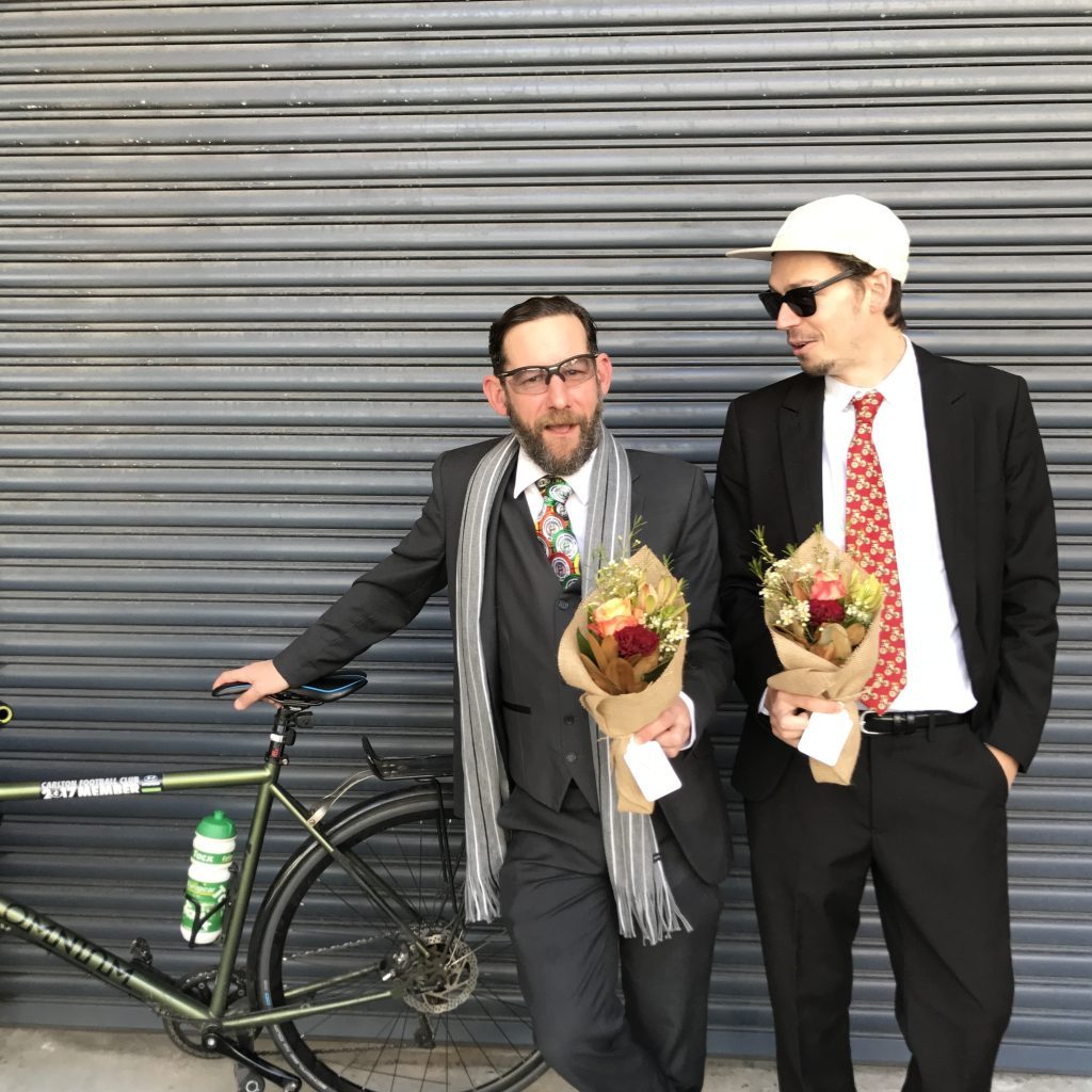 Bike courier dressed in suit loading flowers onto cargo bike